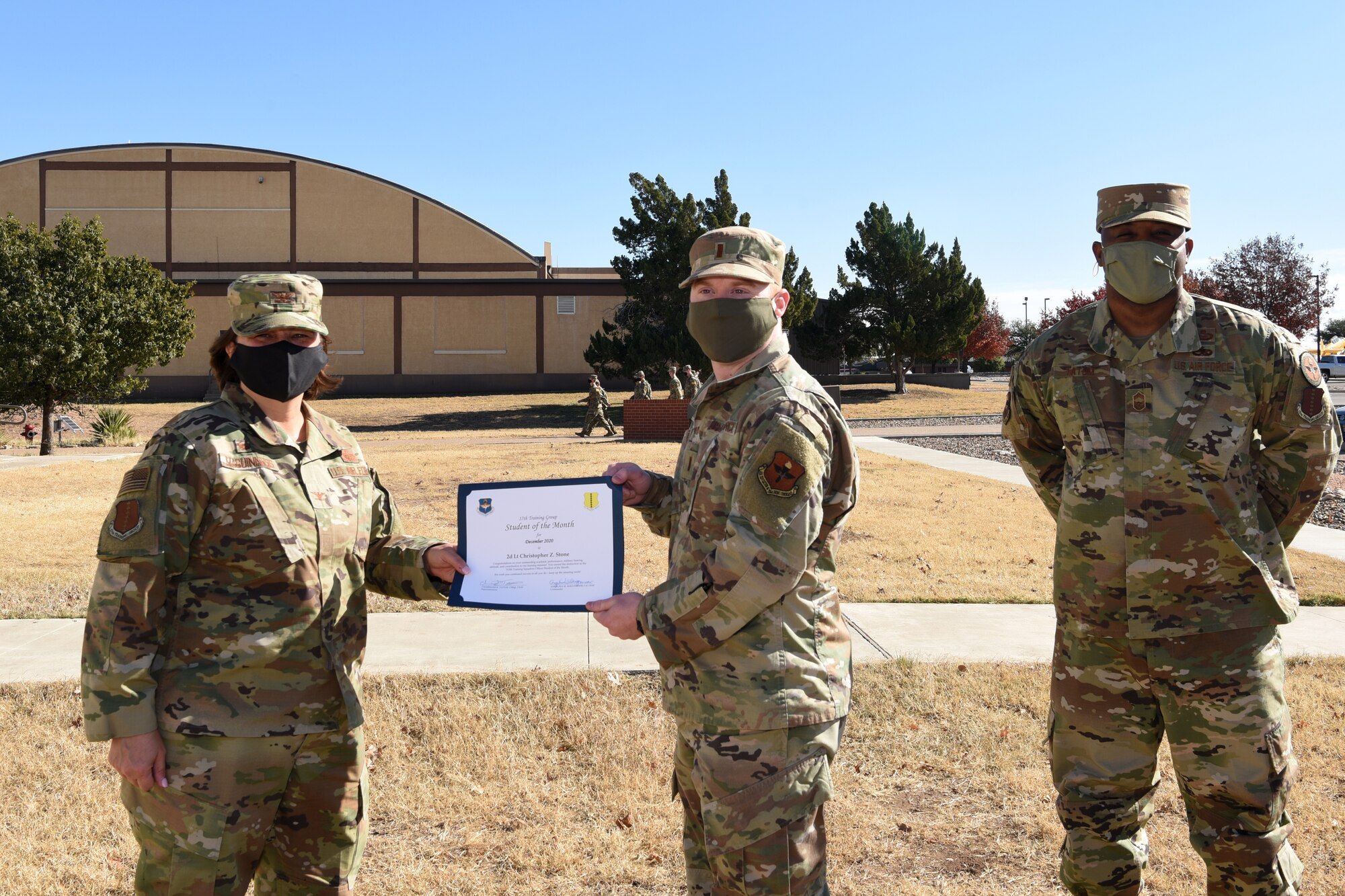 U.S. Air Force Col. Angelina Maguiness, 17th Training Group commander, presents 2nd Lt. Christopher Stone, 315th Training Squadron student, with the 315th TRS Officer Student of the Month Award at outside of the Brandenburg Hall on Goodfellow Air Force Base, Texas, Dec. 11, 2020. Stone worked hard for his award and had shown his dedication to his squadron and the training he received at Goodfellow. (U.S. Air Force photo by Senior Airman Abbey Rieves)