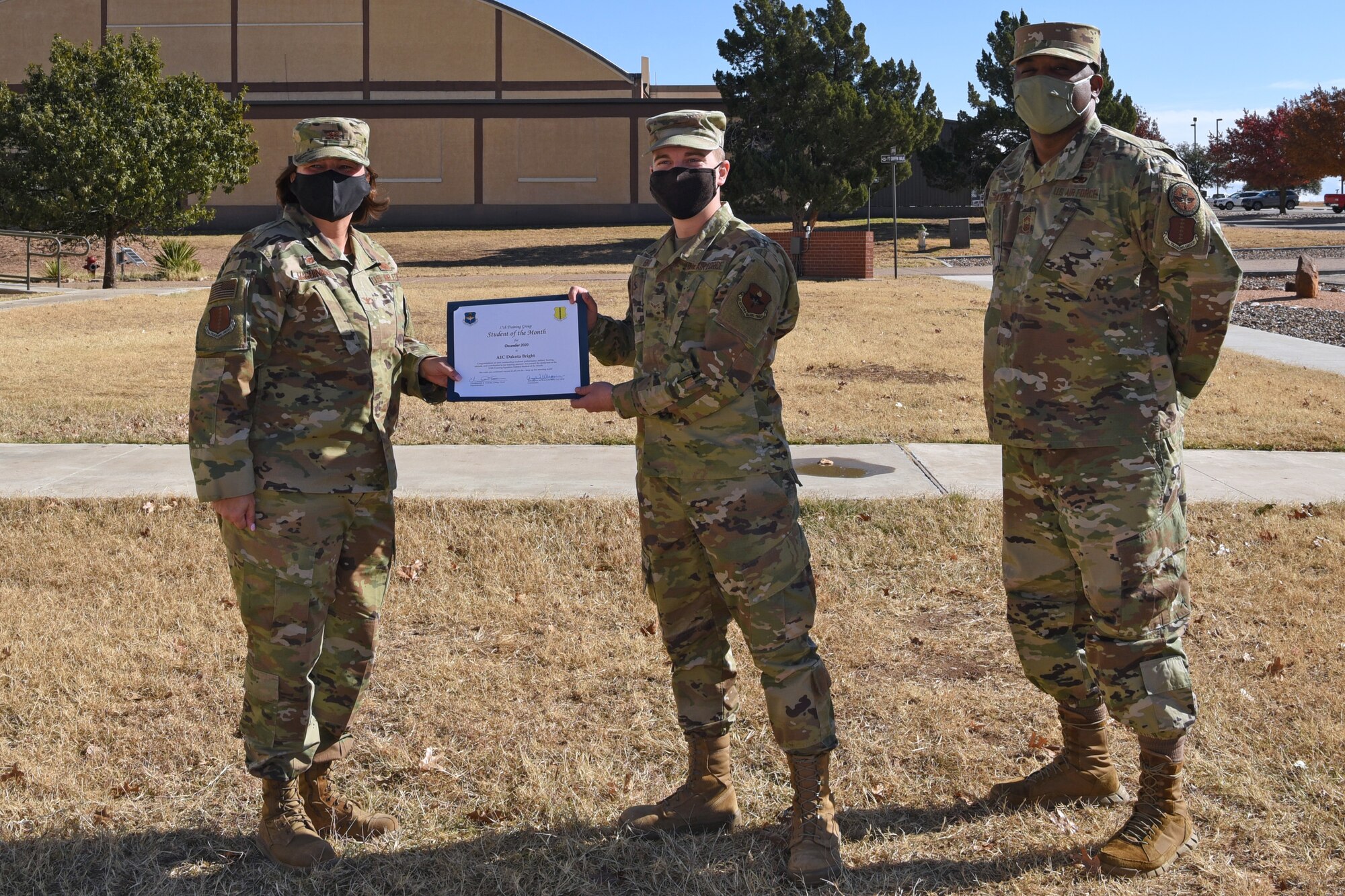 U.S. Air Force Col. Angelina Maguiness, 17th Training Group commander, presents Airman 1st Class Dakota Bray, 315th Training Squadron student, with the 315th TRS Student of the Month award outside of the Brandenburg Hall on Goodfellow Air Force Base, Texas, Dec. 11, 2020. Bright worked hard for his award and had shown his dedication to his squadron and the training he received at Goodfellow. (U.S. Air Force photo by Senior Airman Abbey Rieves)