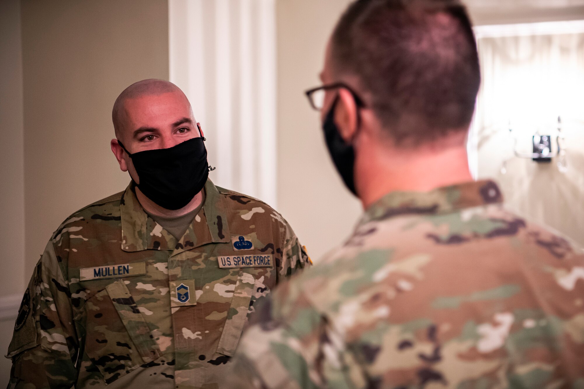 U.S. Air Force Senior Master Sgt. Kyle Mullen, left 423rd Communications Squadron superintendent, speaks with an Airman from the 501st Combat Support Wing prior to a United States Space Force induction ceremony at RAF Alconbury, England, Dec. 18, 2020. Mullen became the first Airman from the 501st Combat Support Wing to transition into the USSF. (U.S. Air Force photo by Senior Airman Eugene Oliver)