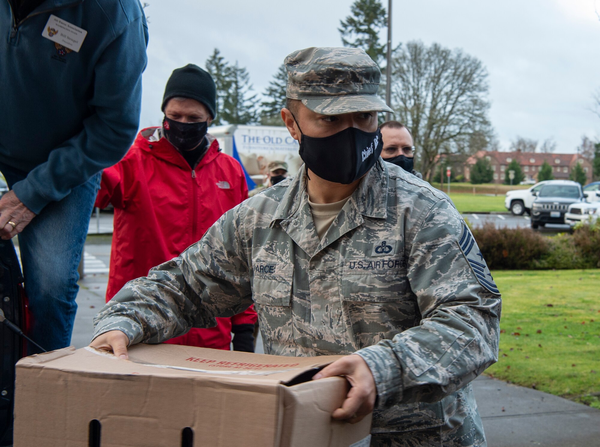 Chief Master Sgt. Joseph Arce, 62nd Airlift Wing command chief, carries a box of hams during Operation Ham Grenade at Joint Base Lewis-McChord, Wash., Dec. 17, 2020. More than 350 hams were donated to McChord Field Airmen by the Air Force Association McChord Field Chapter 334 and Pierce Military Business Alliance. (U.S. Air Force photo by Senior Airman Tryphena Mayhugh)