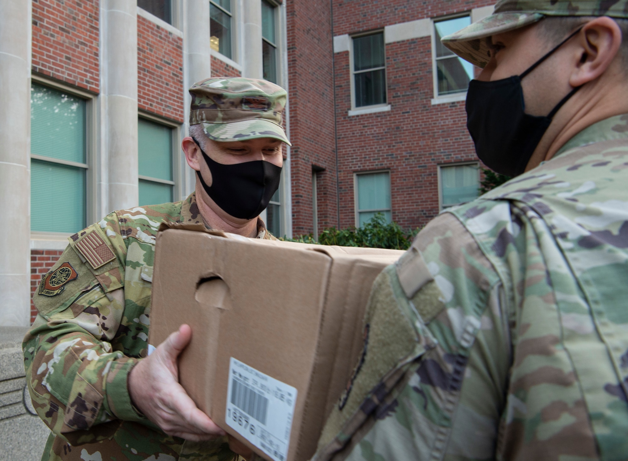 Col. Brian Collins, 62nd Airlift Wing vice commander, receives a box of hams from Operation Ham Grenade at Joint Base Lewis-McChord, Wash., Dec. 17, 2020. The Air Force Association McChord Field Chapter 334 and Pierce Military Business Alliance donated the hams for Team McChord Airmen and their families. (U.S. Air Force photo by Senior Airman Tryphena Mayhugh)