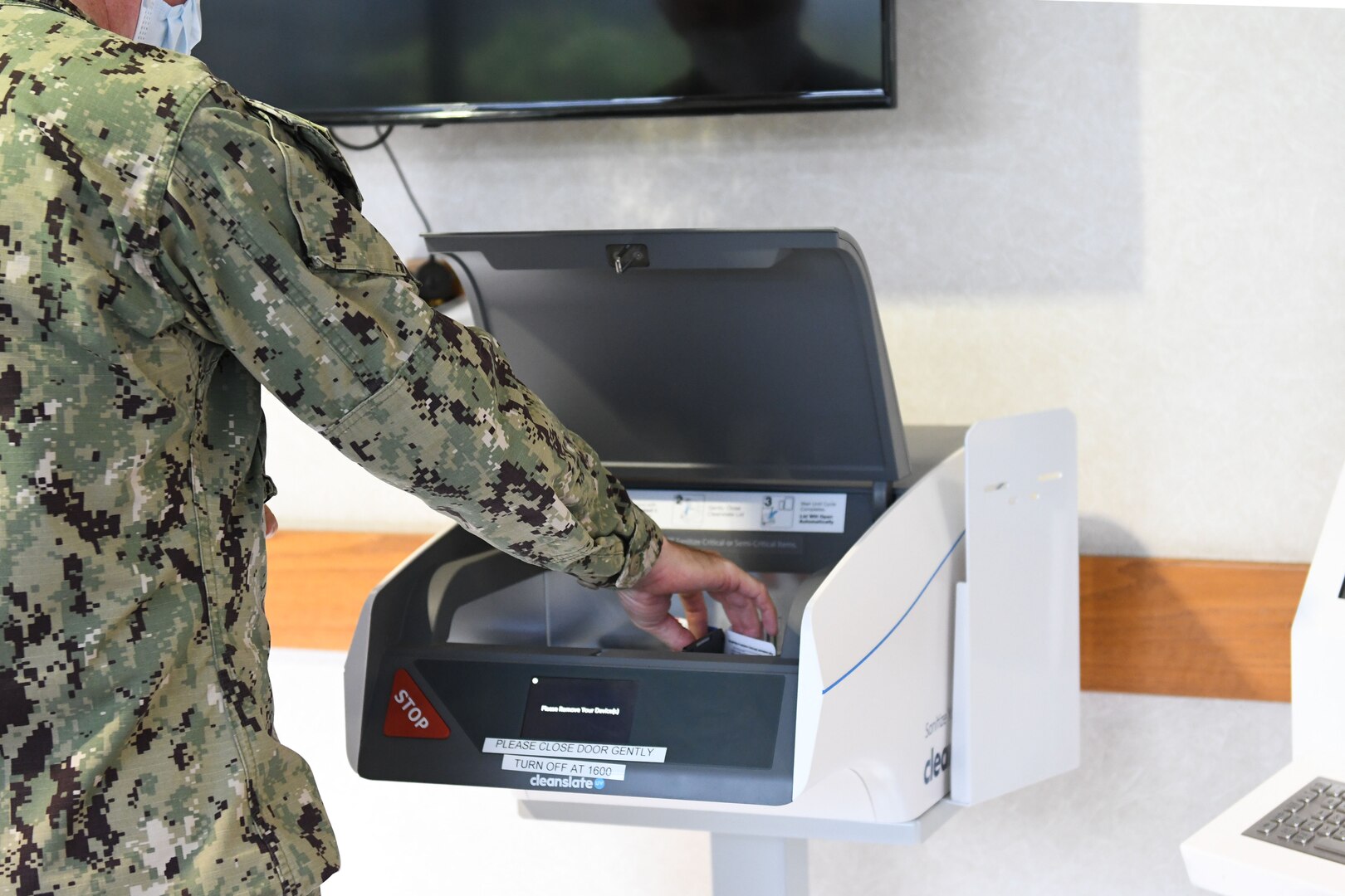 Officer retrieves keys from UV sanitation machine.