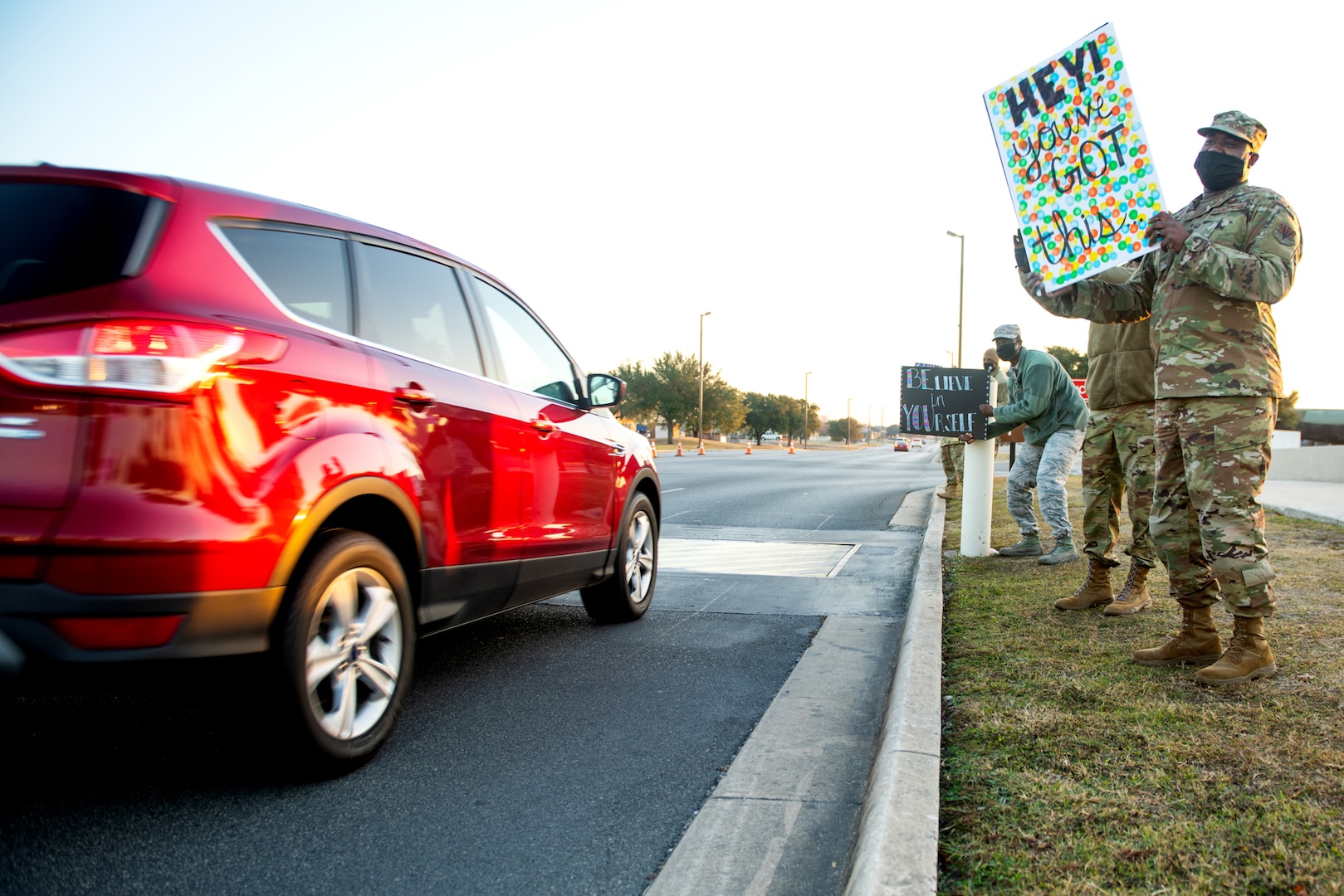 U.S. Air Force military members hold signs to spread holiday cheer for drivers to see Dec. 18, 2020, at Joint Base San Antonio-Lackland, Texas.