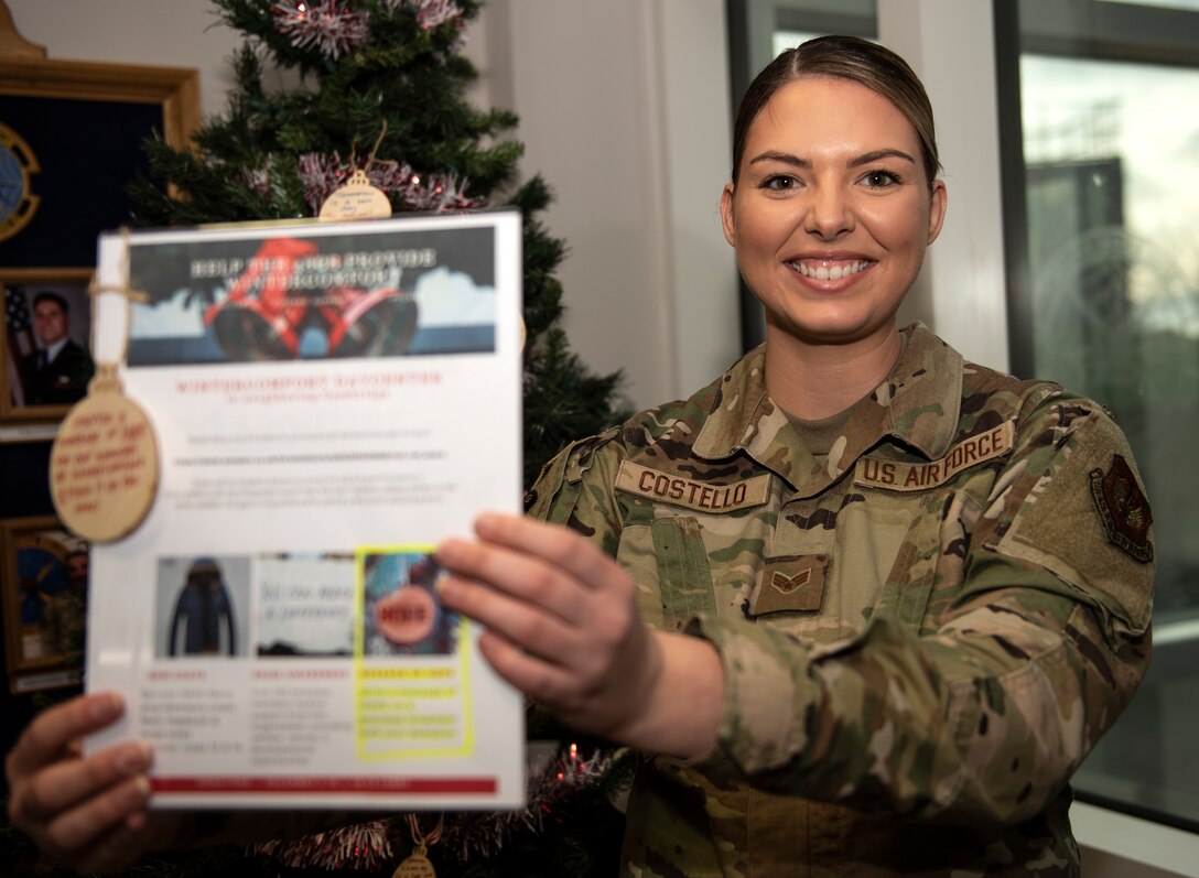 U.S. Air Force Senior Airman Vanessa Costello, 48th Communications Squadron booster club president, holds a warm clothing donation drive sign at Royal Air Force Lakenheath, England, Dec. 16, 2020. The 48th CS organized the clothing drive in support of a local community homeless shelter in the hopes of bringing a little bit more joy into the holiday season. (U.S. Air Force photo by Airman 1st Class Jessi Monte)