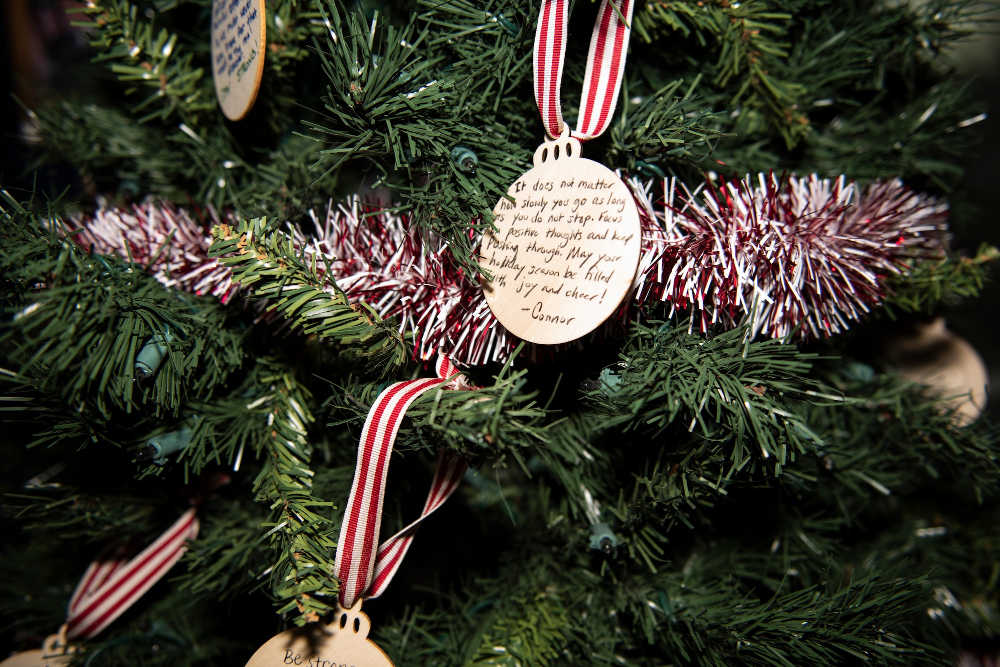 Handwritten messages of positivity and hope hang on a tree in the lobby of the 48th Communications Squadron at Royal Air Force Lakenheath, England, Dec. 16, 2020. The tree was a part of a warm clothing donation drive for a local community homeless shelter. (U.S. Air Force photo by Airman 1st Class Jessi Monte)