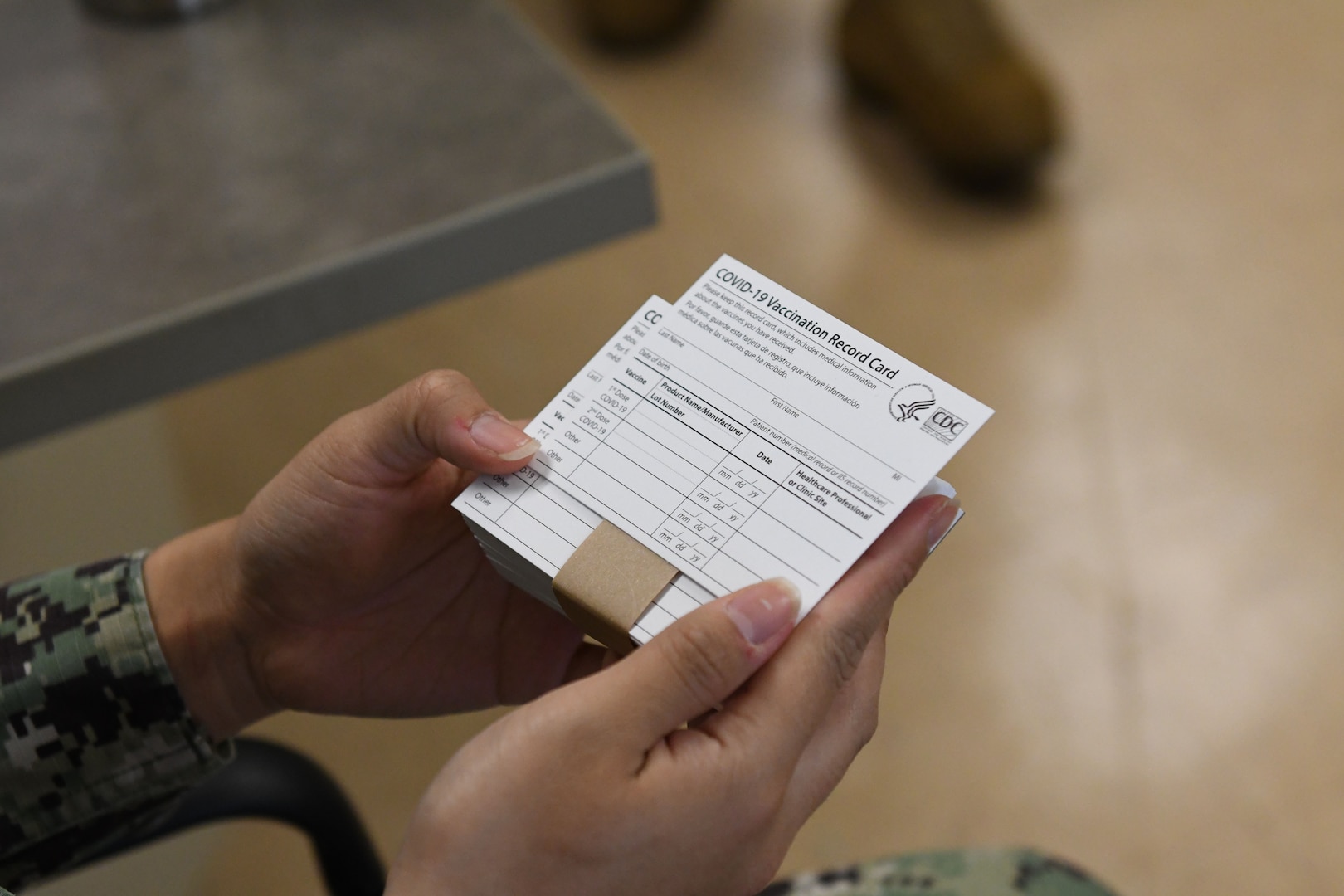 Sailor holds COVID-19 vaccine cards.