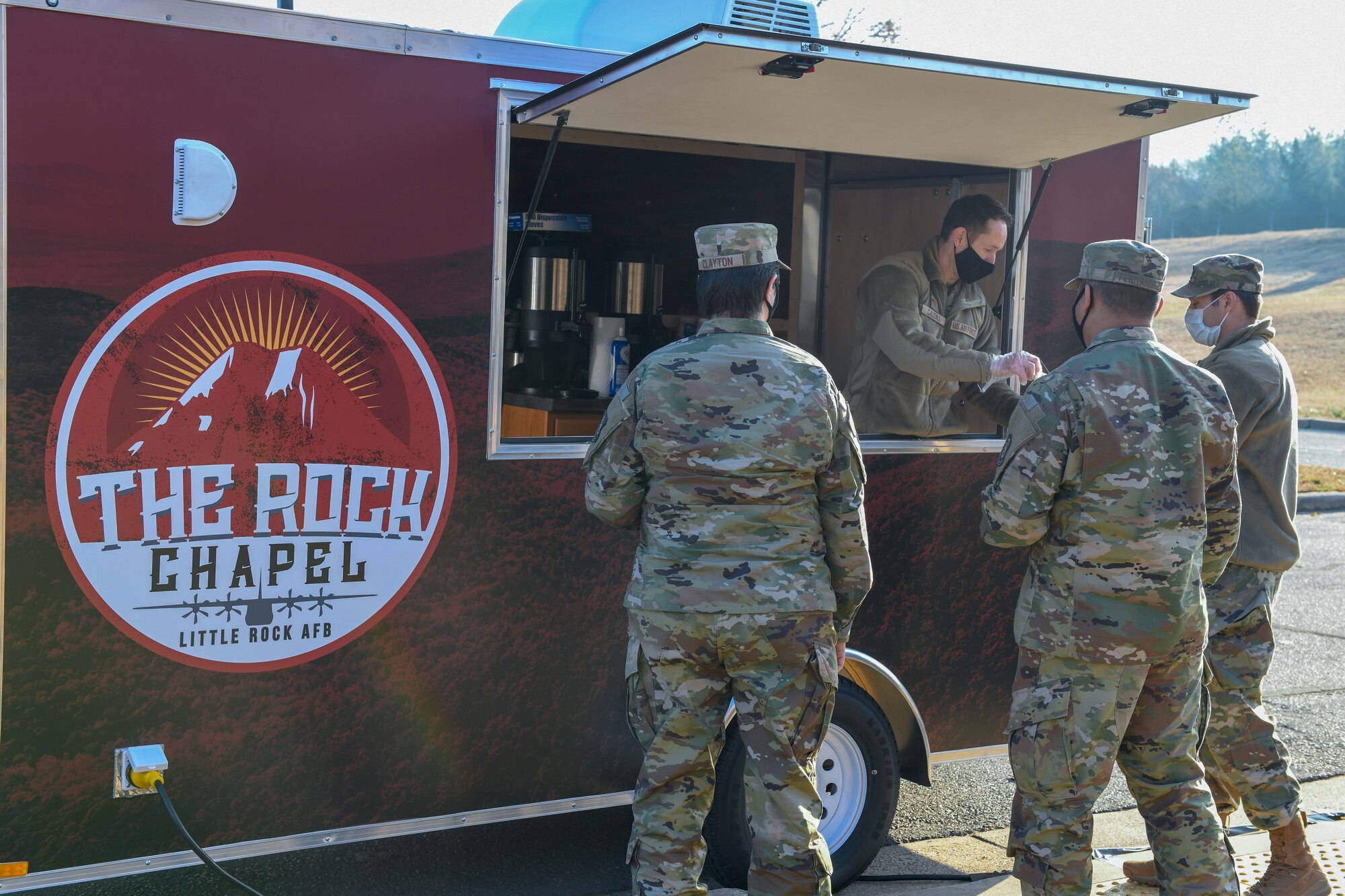a man gives coffee to airmen