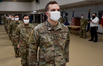 Cadet Dan Borbely and other cadets from the University of Vermont ROTC prepare to receive Military Funeral Honors training certificates from Stephen Holt (background, right) during a ceremony at Camp Johnson, Vermont, Dec. 18, 2020. The cadets completed the first 40-hour course offered by the Vermont National Guard since 2010. The course trains Soldiers how to render honors at funeral services and perform color guards and other ceremonies. Holt is the state MFH program coordinator. (U.S. Army National Guard photo by Don Branum)