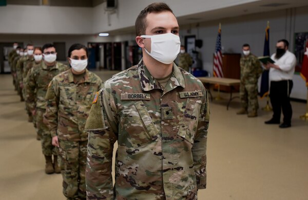 Cadet Dan Borbely and other cadets from the University of Vermont ROTC prepare to receive Military Funeral Honors training certificates from Stephen Holt (background, right) during a ceremony at Camp Johnson, Vermont, Dec. 18, 2020. The cadets completed the first 40-hour course offered by the Vermont National Guard since 2010. The course trains Soldiers how to render honors at funeral services and perform color guards and other ceremonies. Holt is the state MFH program coordinator. (U.S. Army National Guard photo by Don Branum)