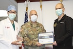Walter Reed National Military Medical Center (WRNMMC) Director Army Col. (Dr.) Andrew Barr (center), along with Army Col. (Dr.) Benjamin Potter, director for surgery at WRNMMC (right) and Air Force Col. (Dr.) Peter Learn, deputy director of surgery for quality at WRNMMC, represent WRNMMC in accepting the award for earning meritorious outcomes for surgical patient care.