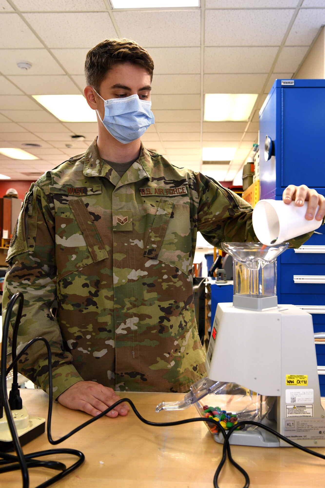 Luke Air Force Base, Ariz. – Senior Airman Gage West, 944th Aeromedical Staging Squadron biomedical technician, runs a sample item through a pill counter while inspecting the device at Luke Air Force Base, Ariz., Nov. 9, 2020. When checking the operability of the counter, the BMET Airmen use different samples varying in shapes and sizes to ensure the machine’s shape modes count them accurately.