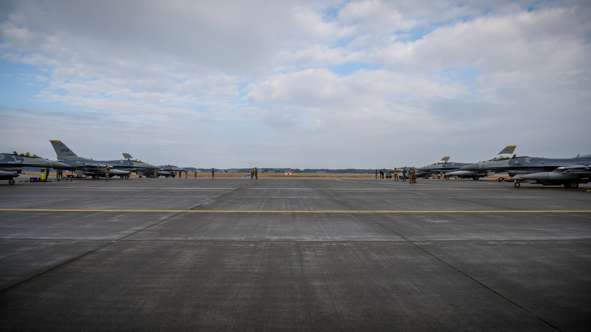 Six U.S. Air Force F-16 Fighting Falcons sit on the flightline during Agile Combat Employment week at Misawa Air Base, Japan, Dec. 10, 2020. This training integrated Multi-Capable Airmen concepts, which focuses on teaching skill-sets outside of one’s respective career field. For example, during this training a 35th Aircraft Maintenance Squadron crew chief taught a 35th Logistics Readiness Squadron Airman how to marshal an F-16 Fighting Falcon. (U.S. Air Force photo by Airman 1st Class China M. Shock)