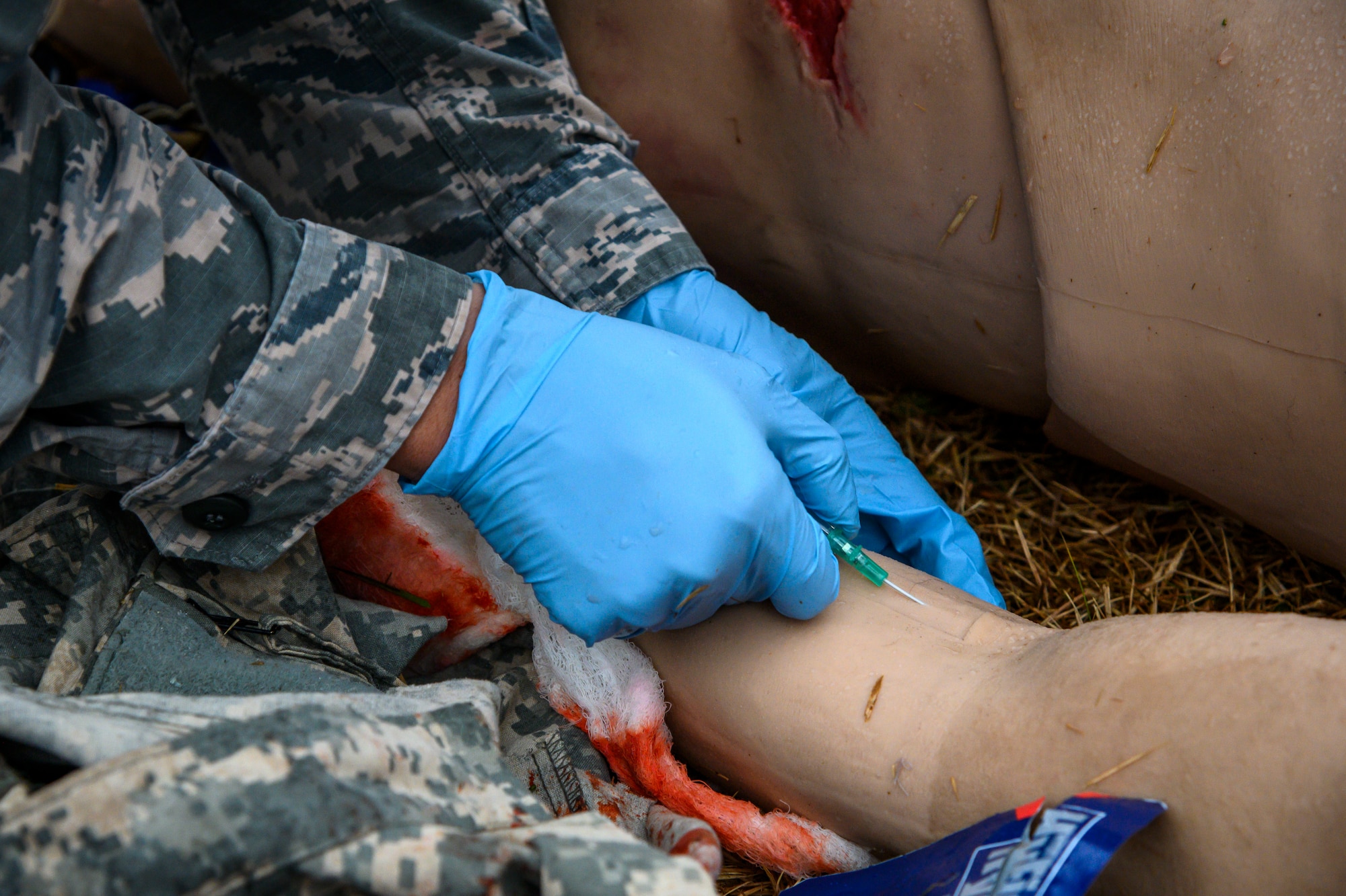 U.S. Air Force Tech. Sgt. Darin Hoki, a 14th Fighter Squadron individual duty medical technician, inserts an intravenous therapy catheter into a stimulated critically injured patient during Agile Combat Employment week at Misawa Air Base, Japan, Dec. 10, 2020. Tactical Combat Casualty Care (TCCC) is a new Air Force initiative, which will eventually replace the current Self-Aid Buddy Care training to better prepare personnel to perform potential lifesaving treatment in a variety of challenging environments, whether in contingency or garrison operations. (U.S. Air Force photo by Airman 1st Class China M. Shock)