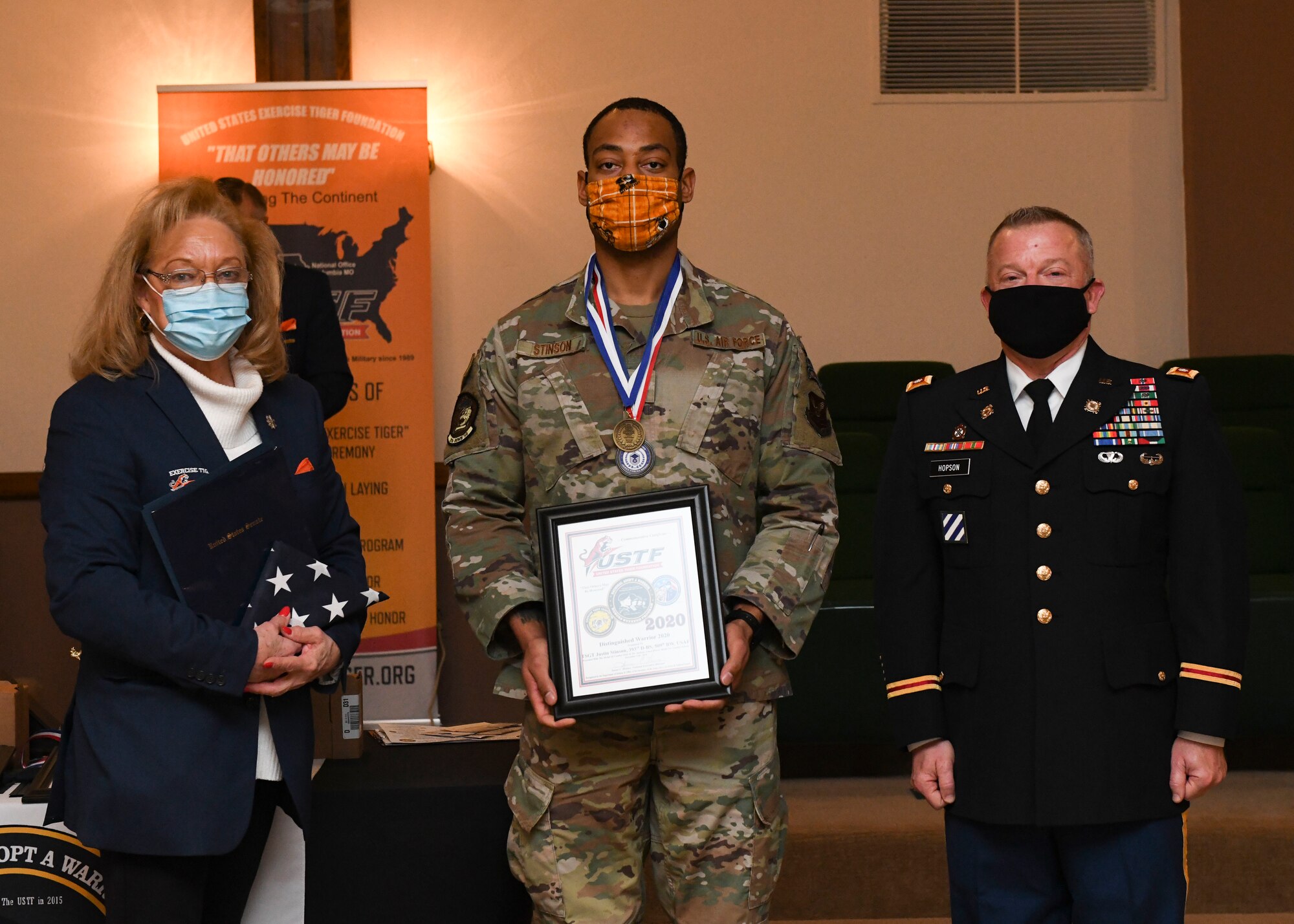 Susan Haines, Exercise Tiger Association national executive director, U.S. Air Force Tech. Sgt. Justin Stinson, 393rd Bomb Squadron superintendent, and U.S. Army Maj. Gen. Levon E. Cumpton, Missouri National Guard Adjutant General, pose with an Annual Adopt A Warrior award plaque, at Columbia, Missouri, Dec. 12, 2020. The ETA hosted the program and honored service members and units for their outstanding achievements and meritorious service. Team Whiteman closely works with its local community to support each other through events and recognition ceremonies. (U.S. Air Force photo by Staff Sgt. Sadie Colbert)