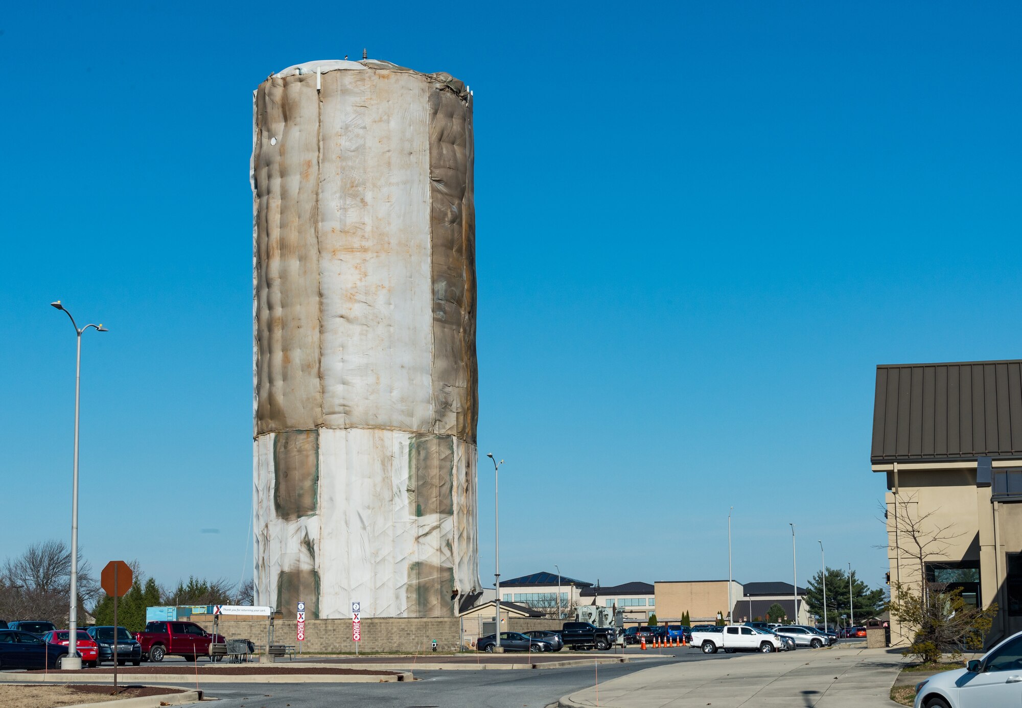 Protective sheathing surrounds scaffolding and the base water tower as employees from a contracted company continue periodic internal and external maintenance to the tower, Dec. 8, 2020, on Dover Air Force Base, Delaware. The water tower is operated by Tidewater Utilities, Inc. who subcontracted the blasting and painting of the tower. Site preparation and mobilization started in August, with a projected completion date at the end of December, weather permitting. (U.S. Air Force photo by Roland Balik)