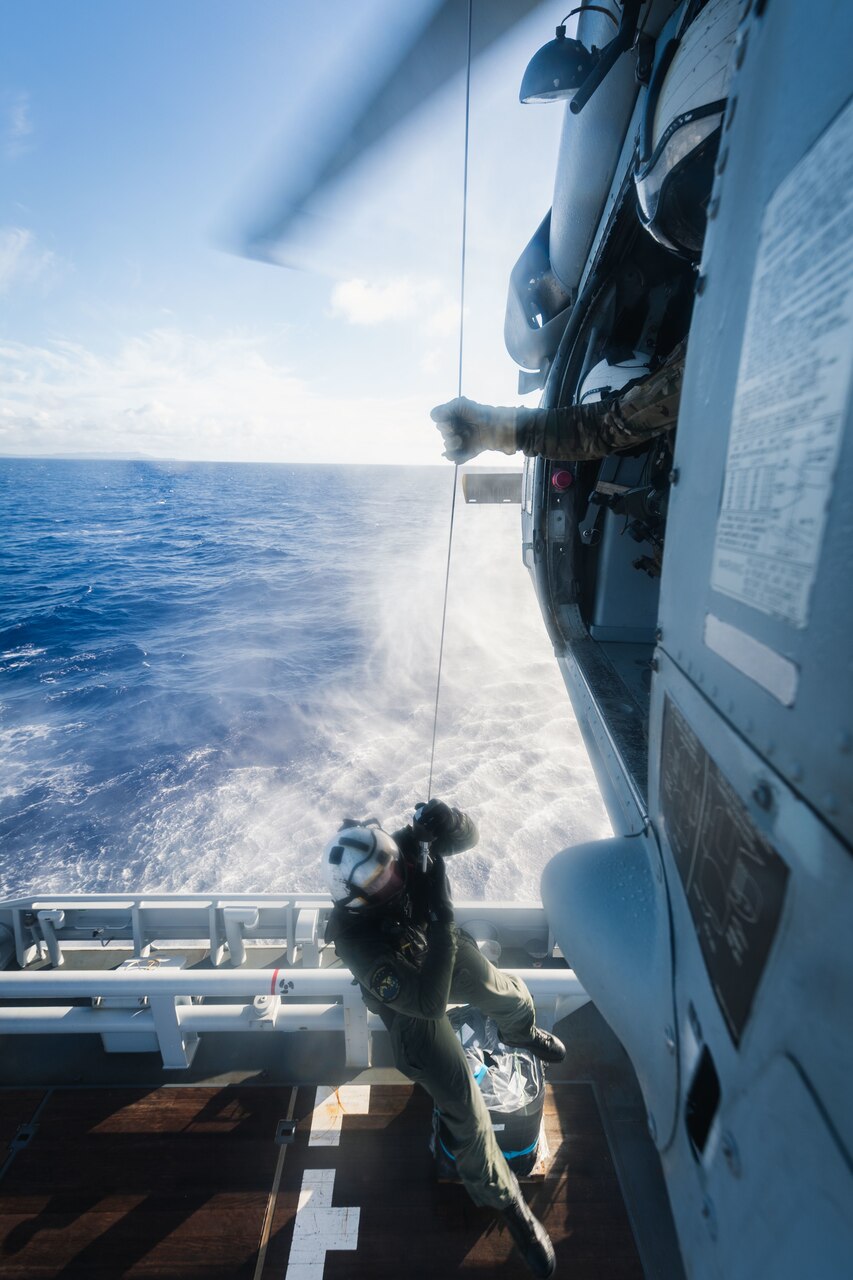 PHILIPPINE SEA (Dec. 10, 2020) Naval Air Crewman (Helicopter) 1st Class Jonathan Kangas, from Newberry, Mich., hoists Naval Air Crewman (Helicopter) 2nd Class Robert Washington, from Birmingham, Mich., both assigned to the “Island Knights'' of Helicopter Sea Combat Squadron 25, from an MH-60S Sea Hawk helicopter during training with French Loire-class tender, and support vessel FS Seine (A 604) to ensure both nations maintain proficiency in personnel recovery while out at sea. HSC-25, the Navy’s only forward-deployed expeditionary helicopter sea combat squadron, provides a multi-mission rotary wing capability for units in the U.S. 7th Fleet area of operations and maintains a Guam-based 24-hour search and rescue and medical evacuation capability, directly supporting the U.S. Coast Guard and Joint Region Marianas. (U.S. Navy photo by Mass Communication Specialist 2nd Class Cole C. Pielop)
