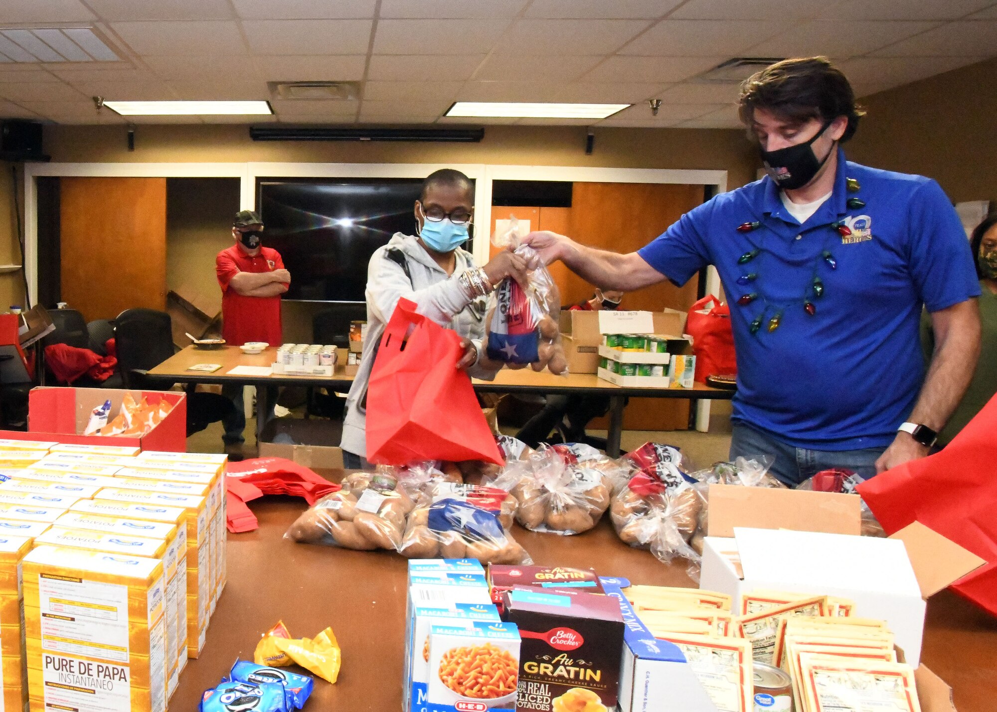 Master Sgt. Rosalind Riderpage, 433rd Airlift Wing administrative assistant (gray shirt), and Brad Tobler, Wish for Our Heroes South Texas chapter director, assemble holiday meal packages during a Wishes for Our Heroes event Dec. 18, 2020 at Joint Base San Antonio-Lackland, Texas. Wish for Our Heroes leads this annual event along with many other programs to help enlisted military members nationwide. (U.S. Air Force photo by Master Sgt. Kristian Carter)