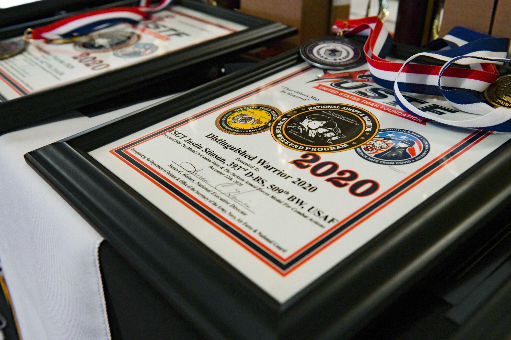 A United States Tiger Foundation award plaque and medals sit on a table prior to an official ceremony at Columbia, Missouri, Dec. 12, 2020. The Exercise Tiger Association hosted the program and honored service members and units for their outstanding achievements and meritorious service. Team Whiteman closely works with its local community to support each other through events and recognition ceremonies. (U.S. Air Force photo by Staff Sgt. Sadie Colbert)