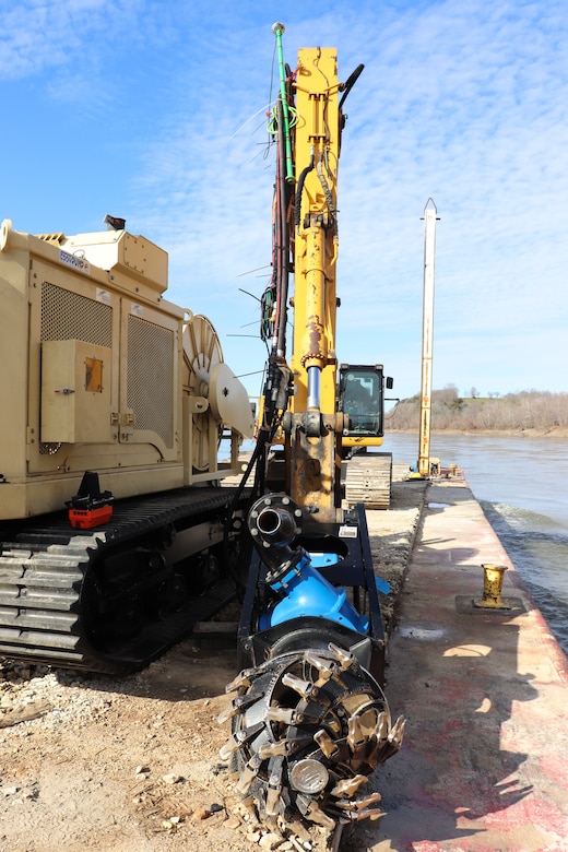 A Kansas City District track-hoe on a barge work boat took part in hydrodynamic dredging operations on the Missouri River November 11, 2020. The hydrodynamic dredge head is mounted on the bucket and the arm directs the flow the desired area of concern to be affected. The Engineering Research and Development Center brought the system to Kansas City District from Vicksburg, Miss., to assist in clearing shoals that developed on the Missouri River due to damages from flooding to the river control structures. The device enabled the combined team to redirect sandy material back into suspension in the current of the river and away from the built-up areas that impede navigation on the river.