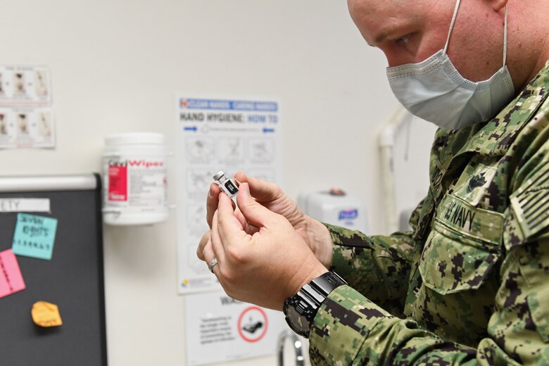 Sailor checks time and date on COVID-19 vaccine.