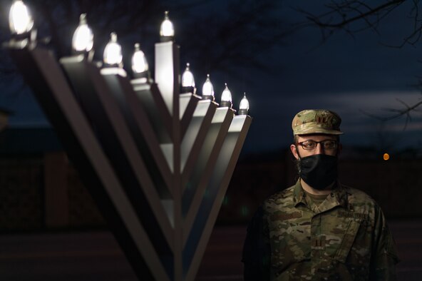 Capt. Levi Welton, 436th Airlift Wing chaplain, lights the Dover Air Force Base menorah Dec. 17, 2020, at Dover Air Force Base, Delaware. Hanukkah, started with the lighting of the first menorah candle the evening of Dec 10. and ends with the eighth candle being lit on the evening of Dec. 17. Hanukkah concluded on the evening of Dec. 18. (U.S. Air Force photo by Roland Balik)