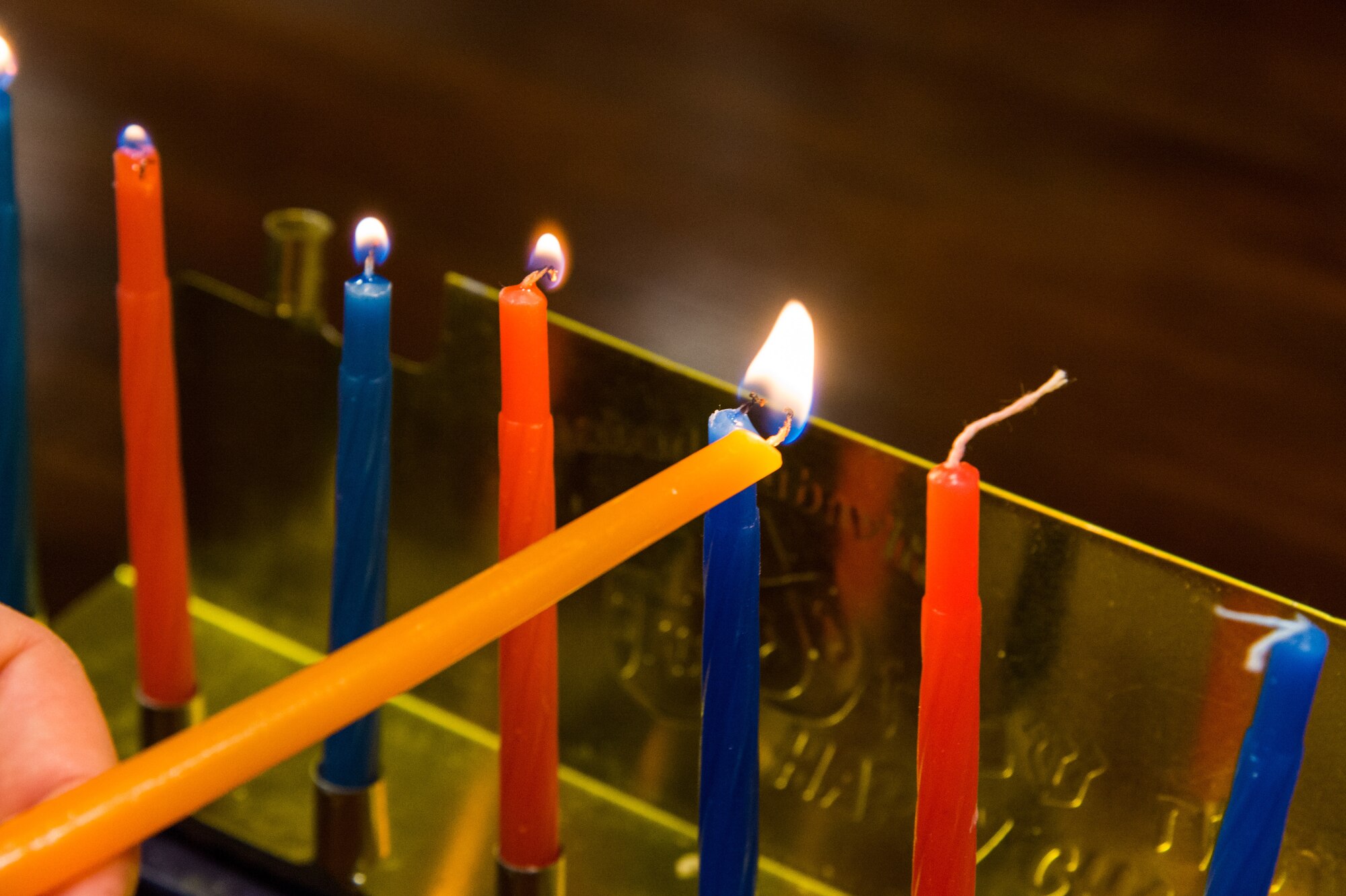 Capt. Levi Welton, 436th Airlift Wing chaplain, lights candles on a menorah Dec. 17, 2020, at Dover Air Force Base, Delaware. The lighting of the first candle on a menorah started on the evening of Dec. 10 with the eighth candle being lit on the evening of Dec. 17. Hanukkah ends the evening of Dec. 18. (U.S. Air Force photo by Roland Balik)