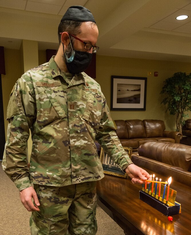 Capt. Levi Welton, 436th Airlift Wing chaplain, lights candles on a menorah Dec. 17, 2020, at Dover Air Force Base, Delaware. The lighting of the first candle on a menorah started on the evening of Dec. 10 with the eighth candle being lit on the evening of Dec. 17. Hanukkah ends the evening of Dec. 18. (U.S. Air Force photo by Roland Balik)