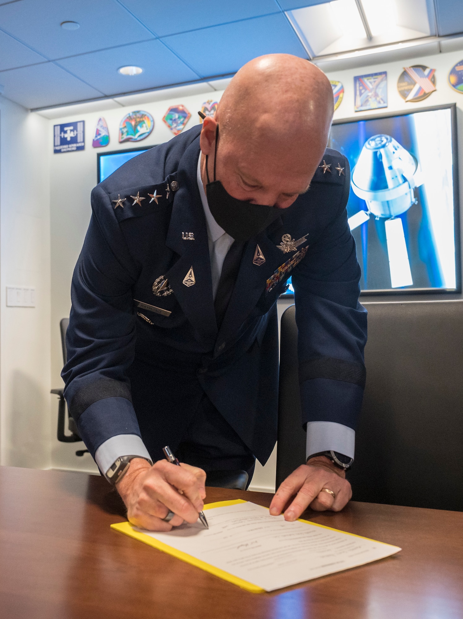 General John Raymond, Chief of Space Operations, U.S. Space Force, signs a document officially transferring U.S. Air Force Colonel, and NASA astronaut, Mike Hopkins to the U.S. Space Force, Friday, Dec. 18, 2020, from the Space Operations Center at NASA Headquarters in Washington