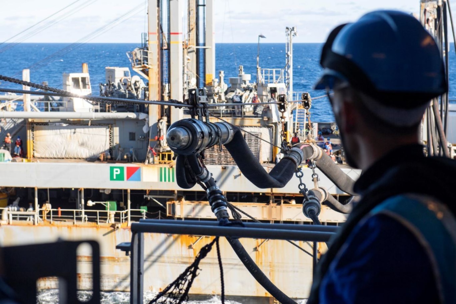 A French Navy Sailor from LHD Dixmude (L9015) observes a fuel probe from USNS Laramie (T-AO 203) during an underway replenishment.