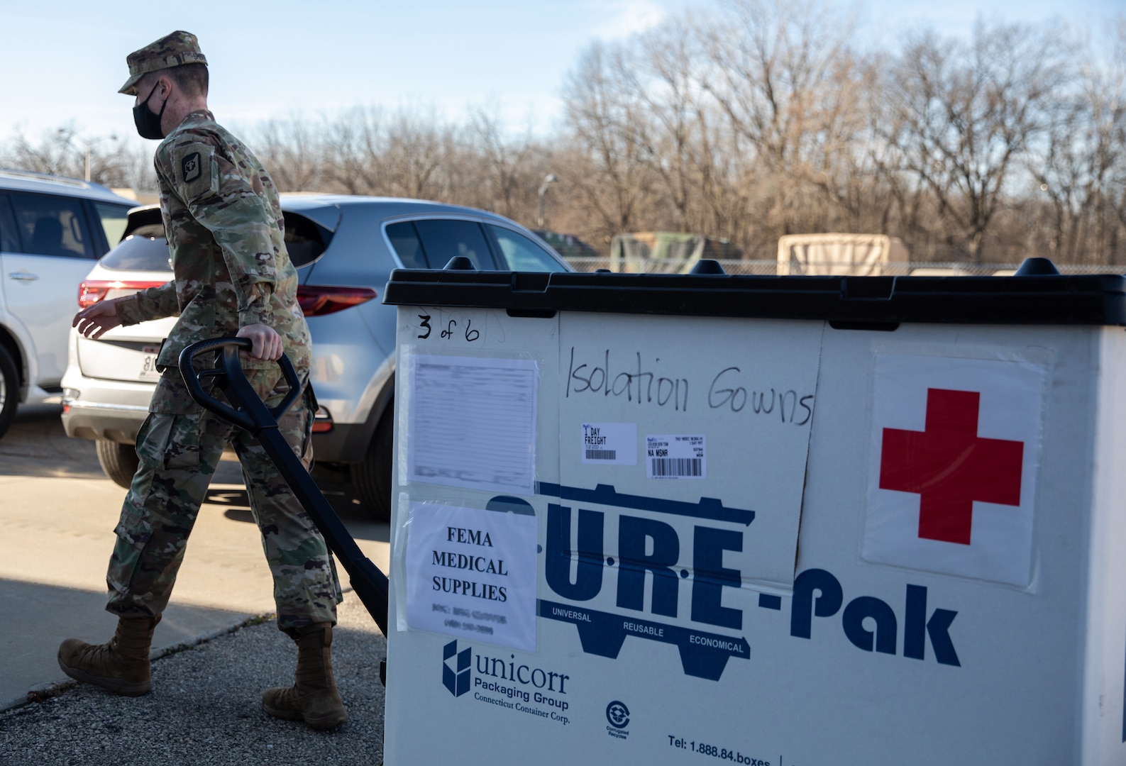 Spc. Liam Sherry-Lamb, a human resources specialist assigned to 62nd Medical Brigade, hauls medical supplies across the Wisconsin Army National Guard Armory in Madison, in preparation for the arrival of Army medical providers who will be supporting local hospitals, Dec. 10, 2020.