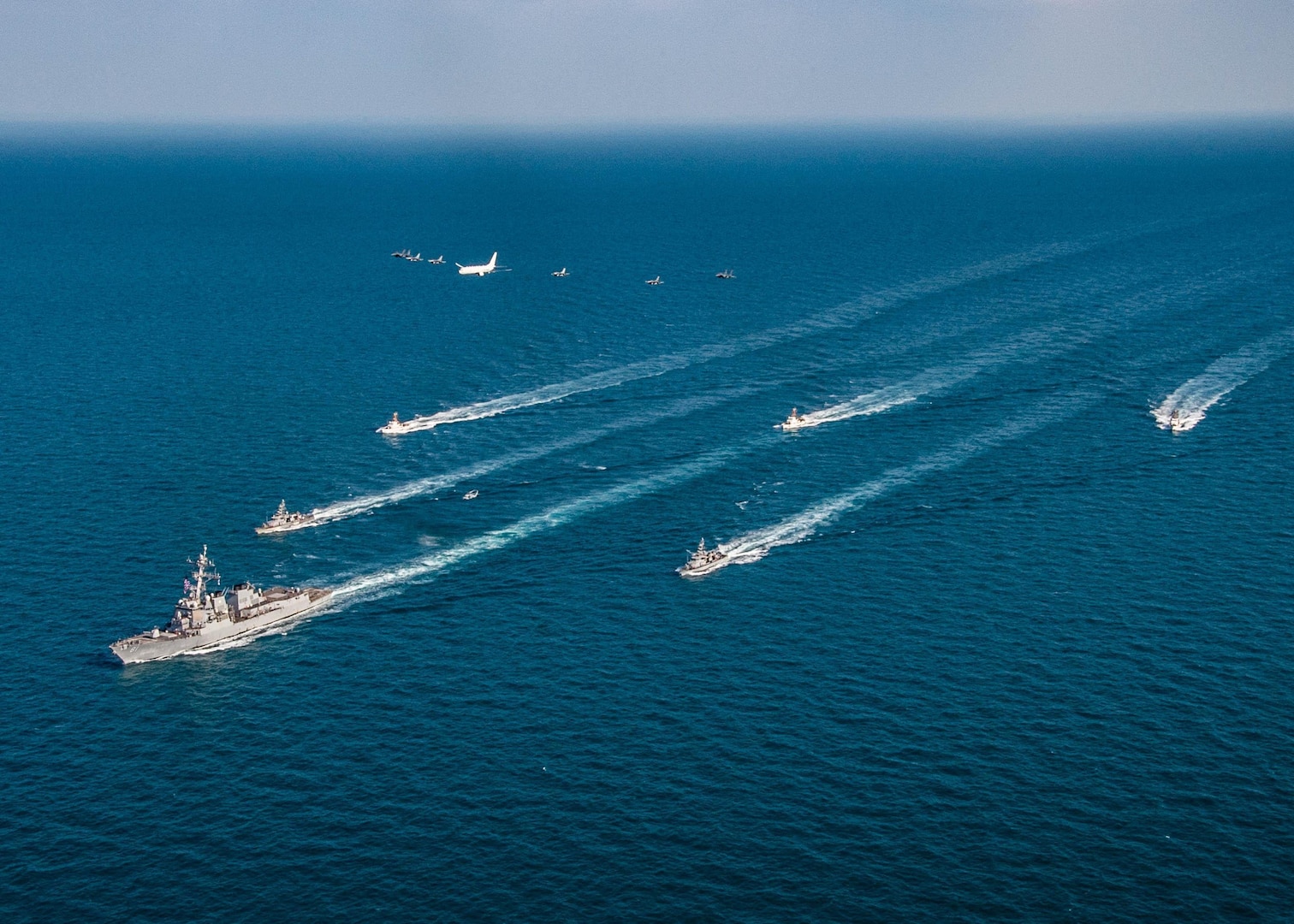 The guided-missile destroyer USS Winston S. Churchill (DDG 81), left to right, the Navy patrol coastal ships USS Firebolt (PC 10), USS Squall (PC 7), center, and the Coast Guard patrol boats USCGC Maui (WPB 1304), USCGC Monomoy (WPB 1326) and USCGC Wrangell (WPB 1322) transit the Arabian Gulf with Royal Saudi Air Force F-15SA fighter jets, U.S. Air Force F-16 Fighting Falcon fighter jets, a U.S. Navy MH-60R Sea Hawk helicopter and a U.S. Navy P-8A Poseidon aircraft during the joint and combined air operations in support of maritime surface warfare (AOMSW) exercise in the Arabian Gulf, Dec. 17. Combined integration operations between joint U.S. forces are regularly held to maintain interoperability and the capability to counter threats posed in the maritime domain, ensuring freedom of navigation and free flow of commerce throughout the region's heavily trafficked waterways.