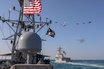 The guided-missile destroyer USS Winston S. Churchill (DDG 81), right, and the Navy patrol coastal ship USS Firebolt (PC 10) transit the Arabian Gulf with Royal Saudi Air Force F-15SA fighter jets, U.S. Air Force F-16 Fighting Falcon fighter jets, a U.S. Navy MH-60R Sea Hawk helicopter and a U.S. Navy P-8A Poseidon aircraft during a joint and combined air operations in support of maritime surface warfare (AOMSW) exercise in the Arabian Gulf, Dec. 18. Combined integration operations between joint U.S. forces are regularly held to maintain interoperability and the capability to counter threats posed in the maritime domain, ensuring freedom of navigation and free flow of commerce throughout the region's heavily trafficked waterways.