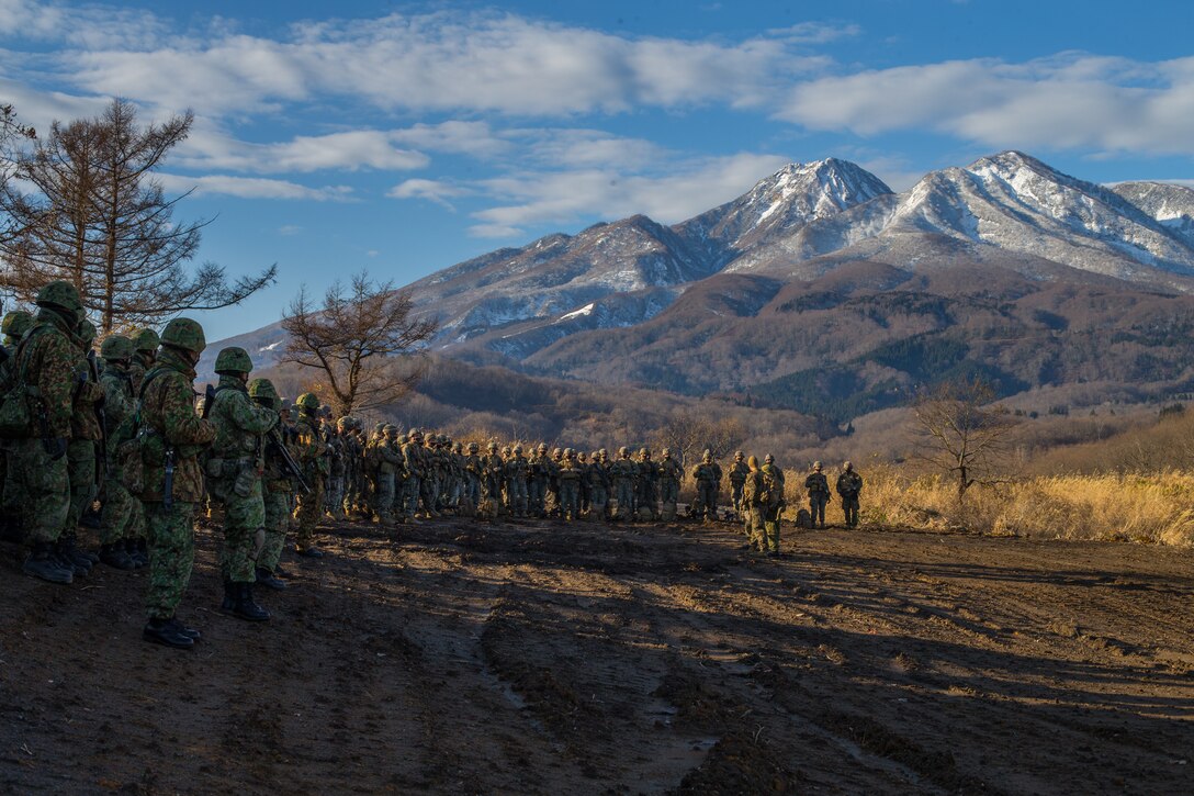 U.S. Marines and troops from the 30th Infantry Regiment, 12th Brigade, Japan Ground Self-Defense Force are briefed on upcoming integrated defensive tactics training during exercise Forest Light 21 in Niigata Prefecture, Japan, Dec. 10.