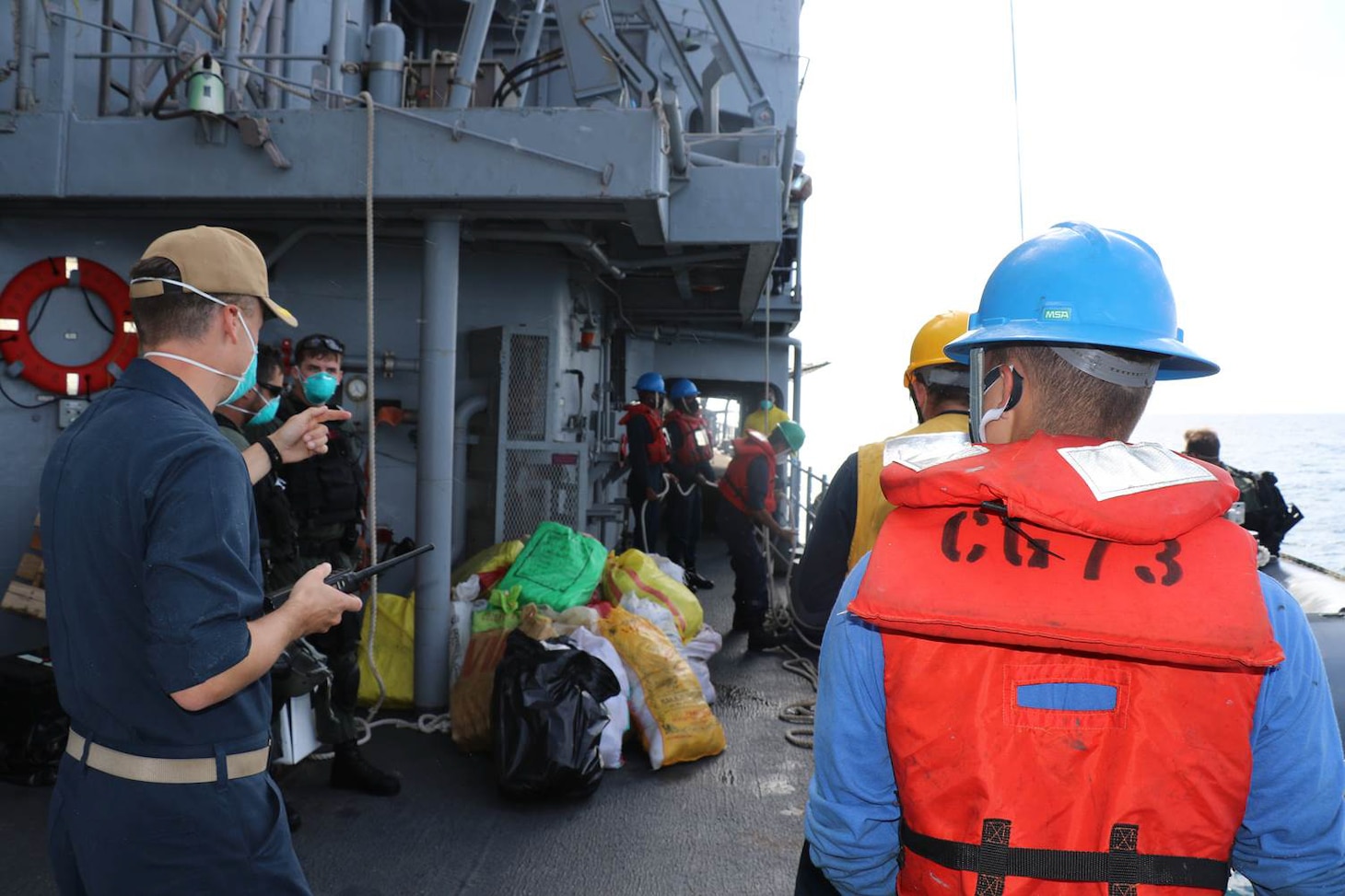 Sailors stationed about the guided-missile cruiser USS Port Royal (CG 73), deployed to U.S. Fifth Fleet and operating in support of the Combined Maritime Forces (CMF), monitor bags suspected narcotics seized from a stateless dhow in the international waters of the North Arabian Sea, Dec. 18. CMF is a multinational maritime partnership which exists to counter illicit non-state actors on the high seas, promoting security, stability and prosperity in the Arabian Gulf, the Red Sea, Gulf of Aden, Indian Ocean and Gulf of Oman. CTF 150 conducts maritime security operations outside the Arabian Gulf to disrupt criminal and terrorist organizations, ensuring legitimate commercial shipping can transit the region free from non-state threats.