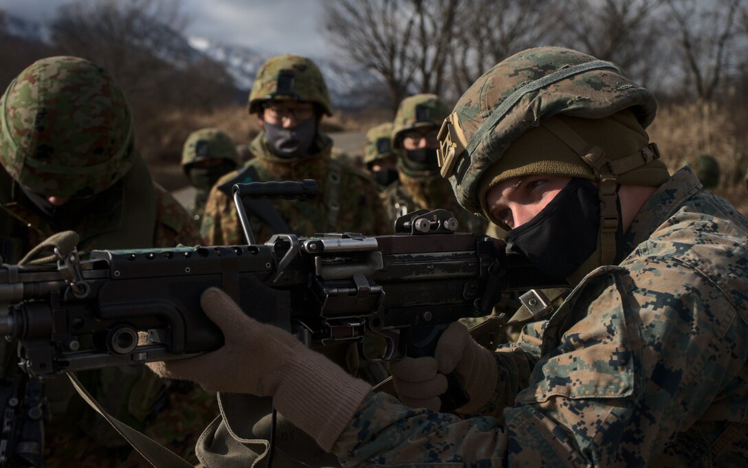 U.S. Marines and members of the Japan Ground Self-Defense Force's 30th Infantry Regiment examine each other's weapons as part of exercise Forest Light in mainland Japan, Dec. 11.