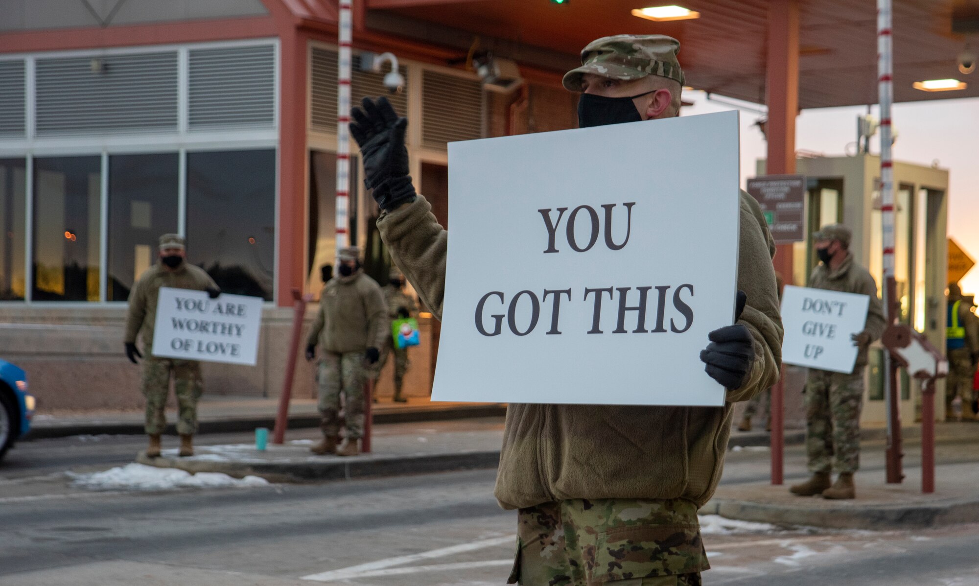 Service member holds up encouraging sign