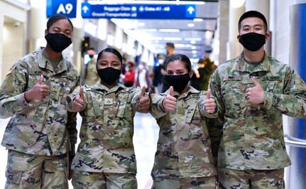 U.S. Army Medical Center of Excellence Soldiers headed to Holiday Block Leave from the San Antonio International Airport demonstrate their enthusiasm for the well-deserved break Dec. 19.