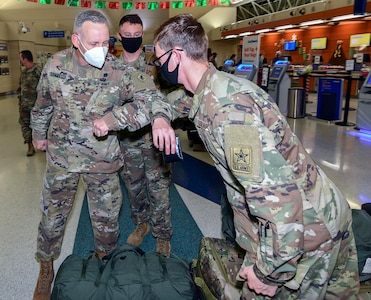 Maj. Gen. Dennis LeMaster (center) offers elbow bumps, the COVID greeting of the day, to Soldiers departing training at the U.S. Army Medical Center of Excellence for Holiday Block Leave Dec 19.