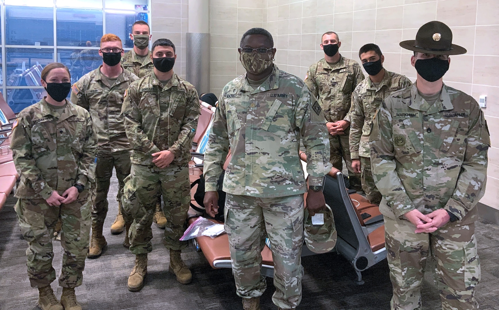 Drill Sergeant Jeffrey Markham (far right) and Chaplain (Maj.) Oyedeji Idowu (center) speak with Soldiers in training at the U.S. Army Medical Center of Excellence as they await flights from the San Antonio International Airport for Holiday Block Leave Dec. 19.