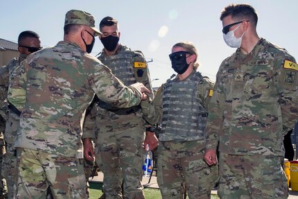 Gen. Paul Funk II, U.S. Army Training and Doctrine commander, presents the winning team of the Best Advanced Individual Training Medic Competition a commander’s coin for excellence at Joint Base San Antonio-Fort Sam Houston Dec 17. The winners (from left) are 68W combat medics in training: Pvt. Aneese Williams, Pvt. Aaron Freeman, Pvt. Jade Berget and Pvt. Christian York.