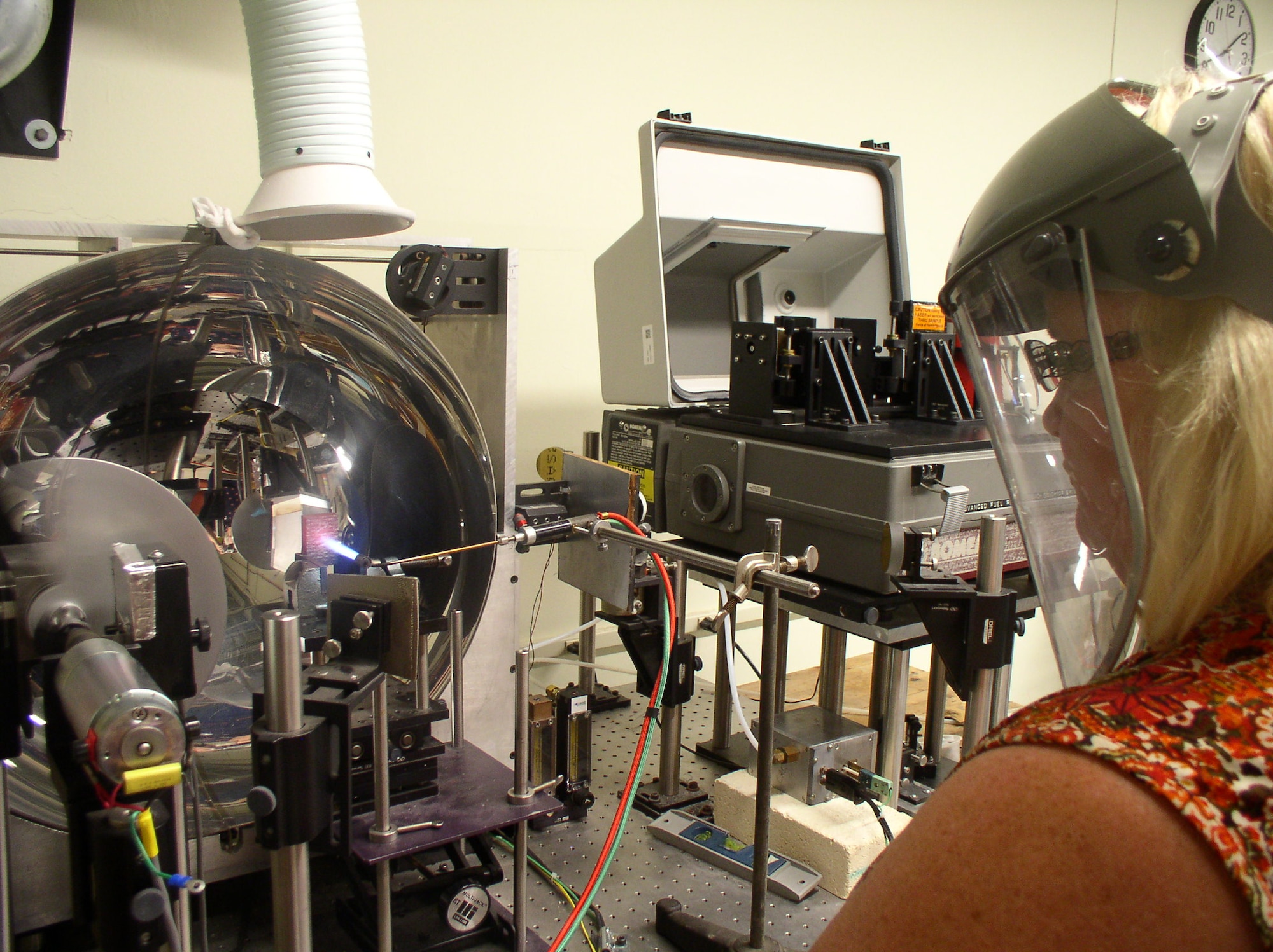 Annette Painter, AEDC Fellow and instrument technician specialist, operates the legacy emissometer in the calibration laboratory of the Arnold Engineering Development Complex Aerothermal Measurements Laboratory at Arnold Air Force Base, Tenn. An acetylene torch is positioned to heat a sample before measuring the emissivity when bombarded by a blackbody simulator. The enhanced emissometer being developed for the ATML will include a built-in heat source and allow for measurements at additional angles. (U.S. Air Force photo)