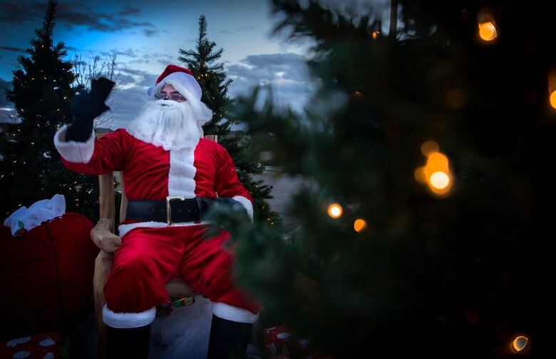 Santa Claus sits and waves to passers by at Schriever Air Force Base's housing area.