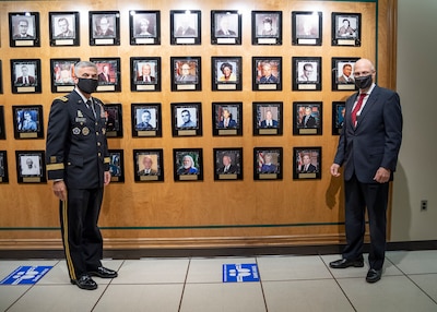 GEN Paul M. Nakasone, Commander, U.S. Cyber Command, Director, NSA/Chief CSS, (left) and George Barnes, NSA Deputy Director, (right) stand for a photo near the portraits of this year’s inductees into the NSA/CSS Cryptologic Hall of Honor