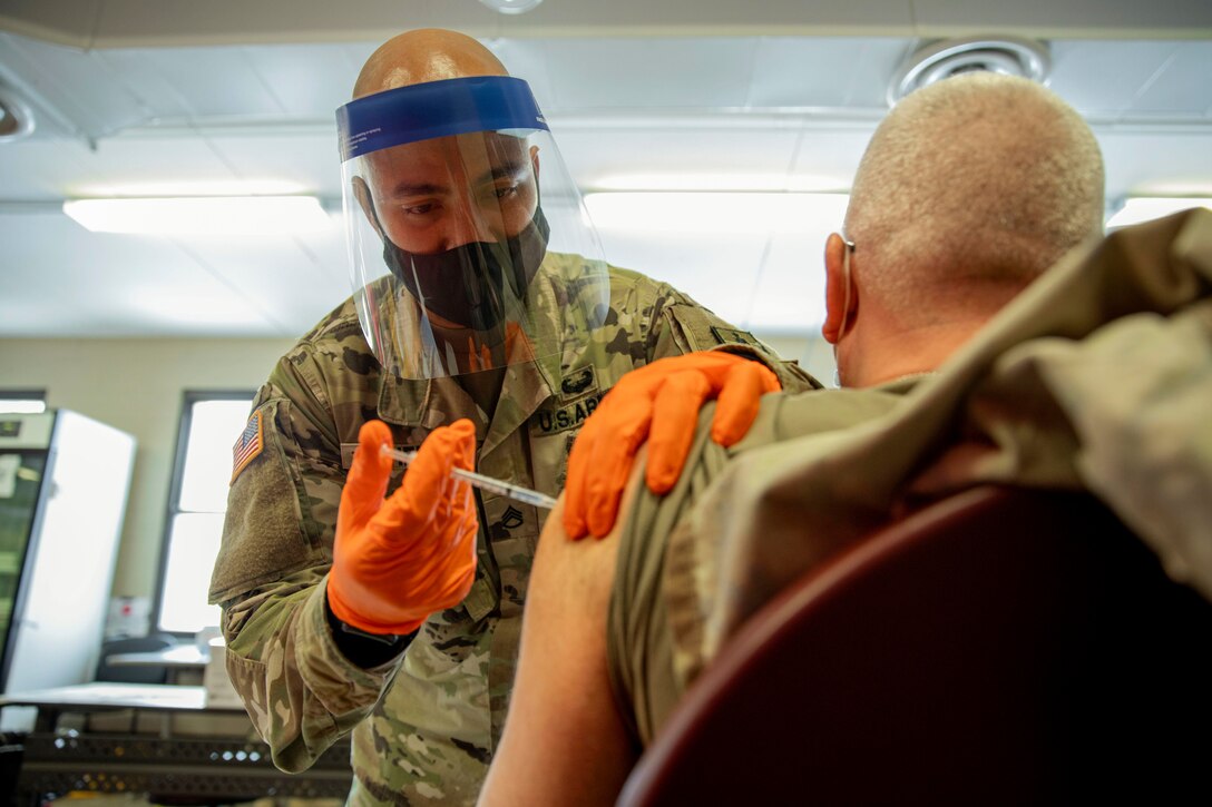 A soldier administers the COVID-19 vaccine.