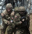 Spc. Hunter Whittaker, infantryman with the Oregon Army National Guard 162nd Infantry Company, 2nd Infantry Battalion, 41st Infantry Brigade Combat Team, braces Polish soldiers on external-load hook-up operations at Camp Marechal De Lattre De Tassigny, Kosovo, July 14. Soldiers with the Oregon and Colorado Army National Guard hosted several training exercises with other multinational partners to increase the readiness of various Kosovo Force missions.