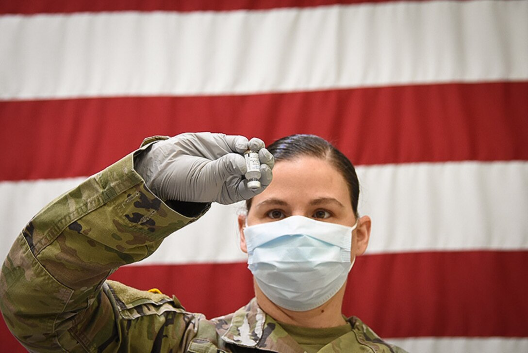 An Army pharmacy technician takes part in an exercise with the COVID-19 vaccine.