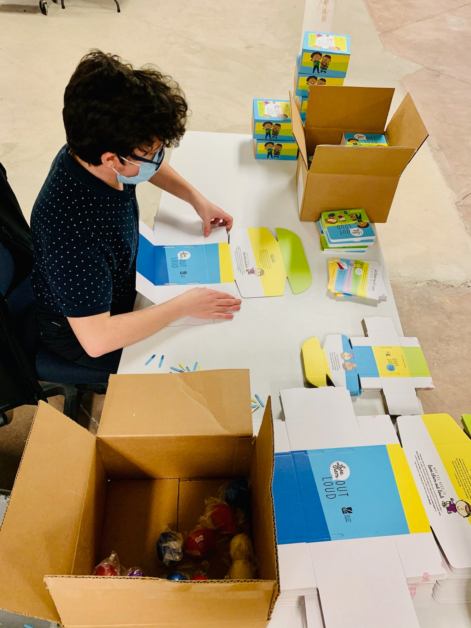 Diego Quevedo of Wright-Patterson Air Force Base’s National Air and Space Intelligence Center builds “Love Them Out Loud” kits during the Dec. 18 volunteer event benefiting the Dayton Metro Library and early childhood literacy.