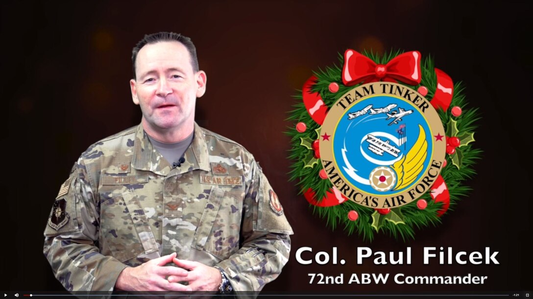 Col. Paul Filcek in video with wreath graphic on right side.