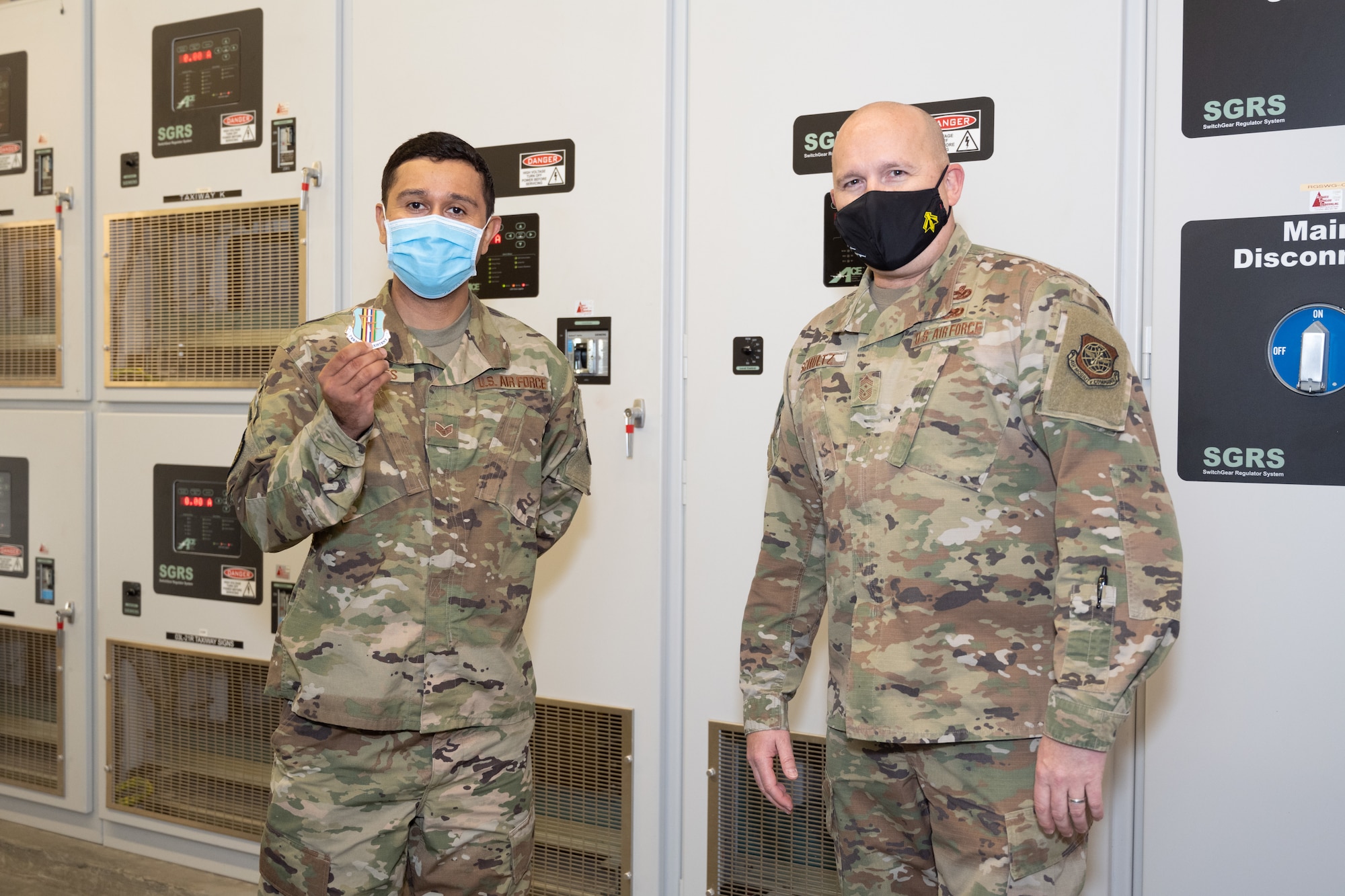Airman receives coin from command chief.