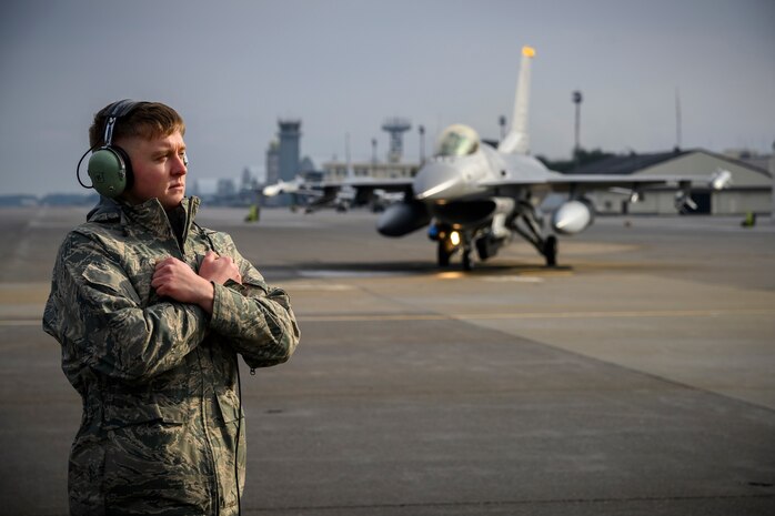 U.S. Air Force Airman Corey Tidwell, a 35th LRS fuels distribution journeyman, prepares to marshal an F-16 Fighting Falcon during Agile Combat Employment week at Misawa Air Base, Japan, Dec. 10, 2020. The 35th LRS tested a new cargo deployment function (CDF) process that centralized representatives from all units and their unpacked cargo in one location to collectively pack individual storage units, reducing the CDF timeline and deployment footprint.